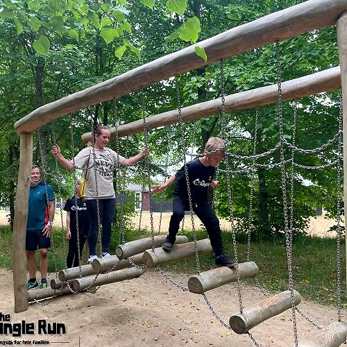 Familie deltager i sjov forhindringsbane. Junglerun Lalandia.