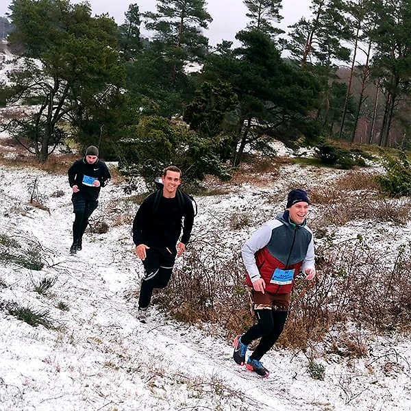 Tre løbere i sneen under VinterTrail Mols Bjerge.