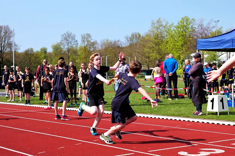 Stafetløb på atletikbane. God stemning og fart på.