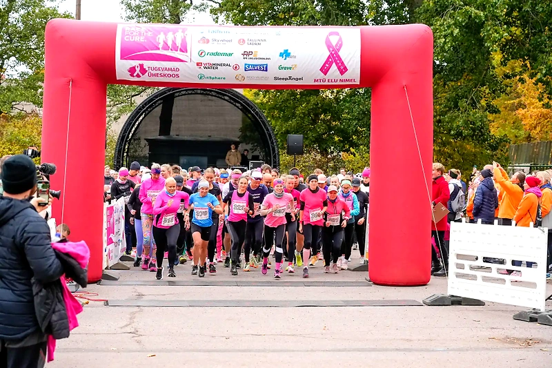 Mother's Day run start, many runners, pink start arch.