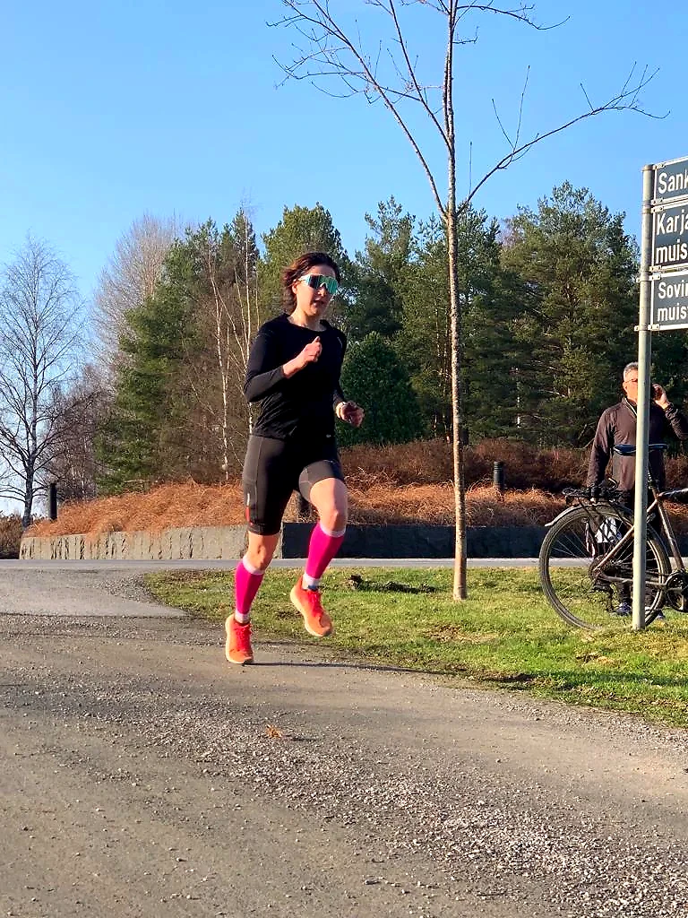 A woman runs in the terrain on a sunny day.
