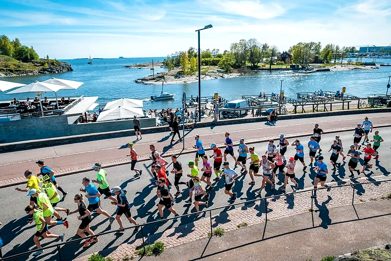 Helsingin kaupunkijuoksupäivän juoksijoita kauniilla rantareitillä.
