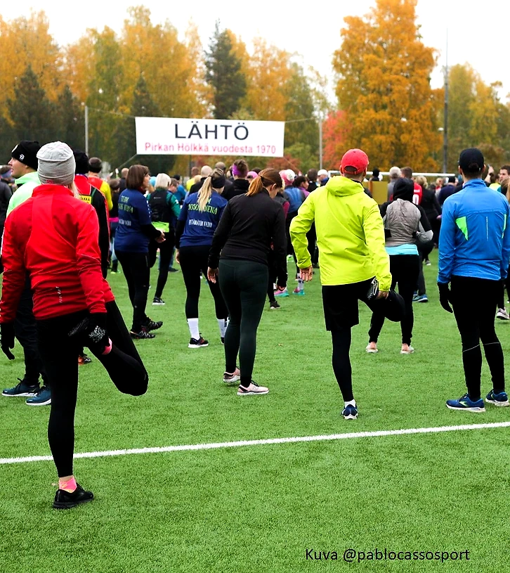 Juoksijat venyttelevät ennen kilpailua.