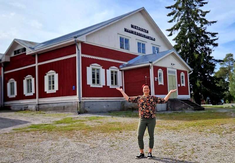 The building of the Mietoinen Farmers' Society. A woman is posing in front of the building.