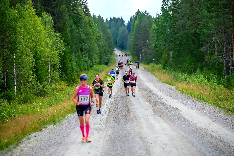 Juoksijoita Raatteen Maratonilla soratiellä.
