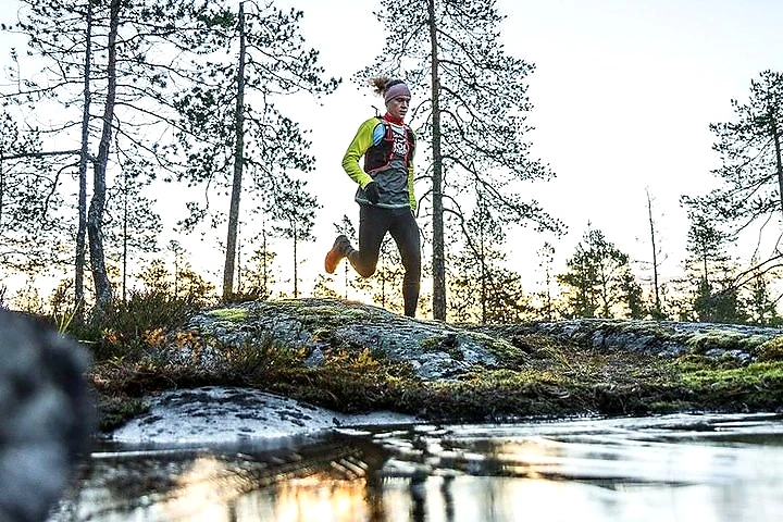 The trail runner is running in the forest, natural lighting and beautiful surroundings.