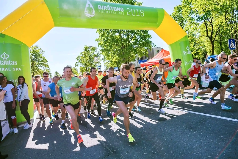 Birštonas Half Marathon: runners start beneath the arch.