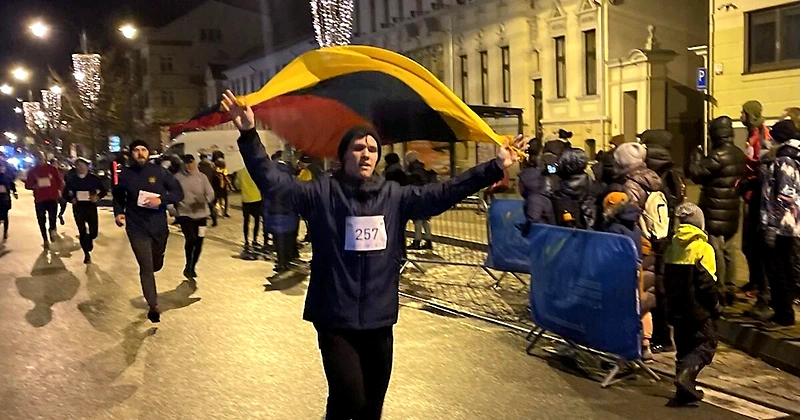 Bėgimo dalyvis su Lietuvos vėliava.