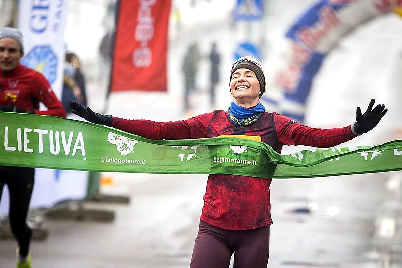 The runner crosses the finish line with a smile.