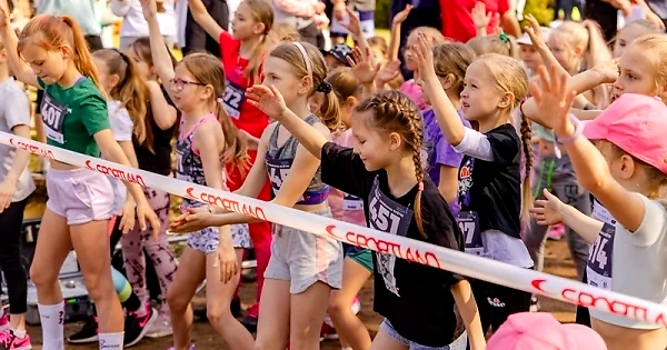 Children in running races, with their arms raised.