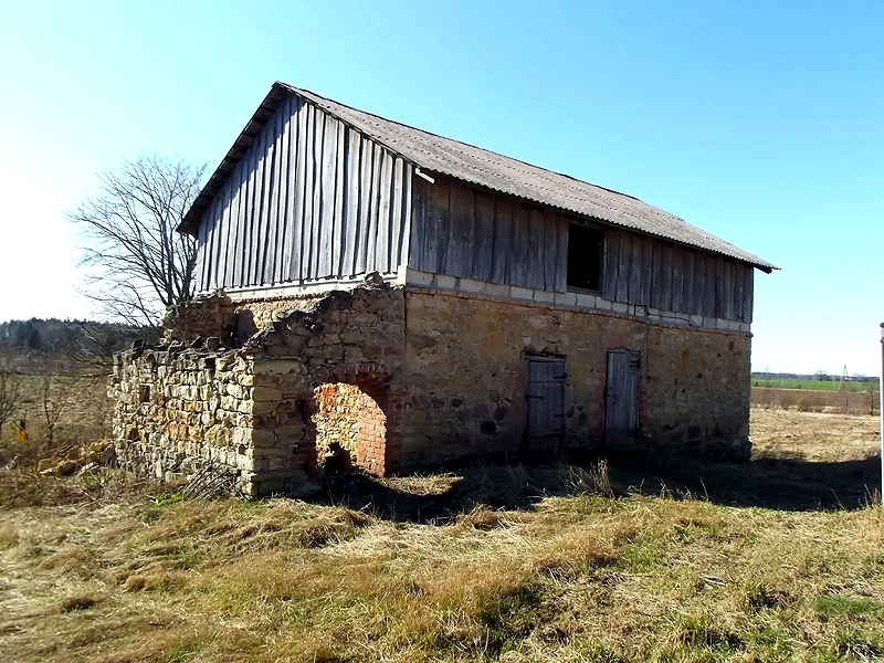 A carefully constructed building in the field, possibly part of a retro running track.