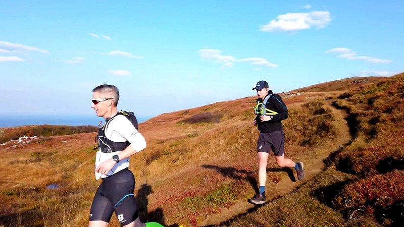 Runners on the trail over Bodøryggen, beautiful nature and blue sky.