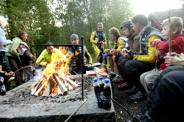 Runners and spectators enjoy themselves around a campfire after or before the race.