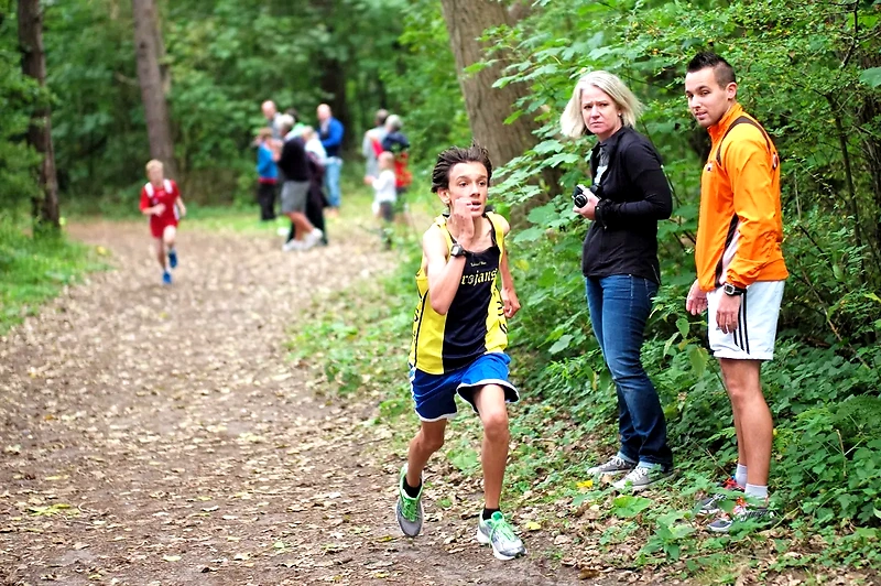 Runner in cross country, people are watching.