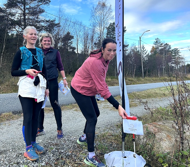 Deltakere ved en sjekkpunkt under et løp i naturen.