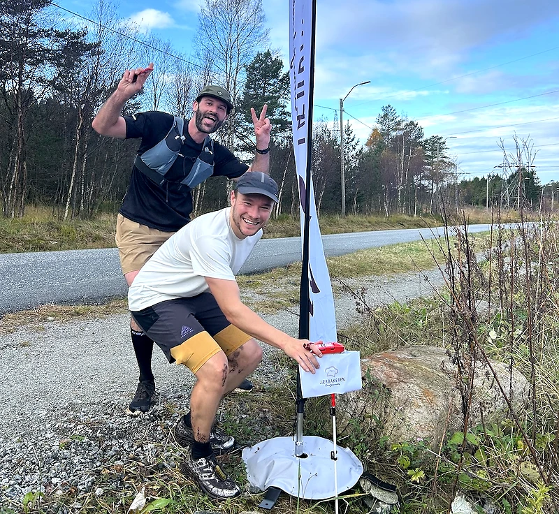 To personer ved et løpsskilt på en grusvei.