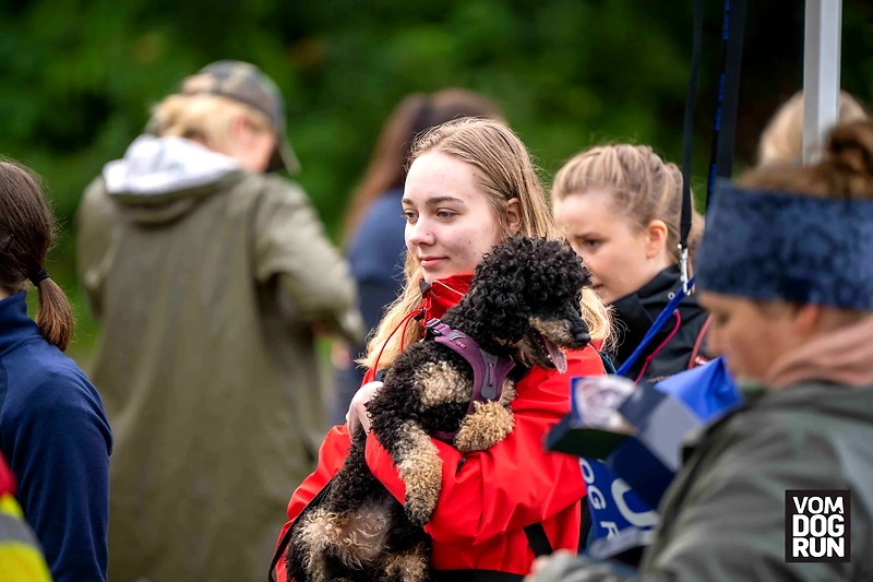 Woman holding a dog at the Dogrun event.