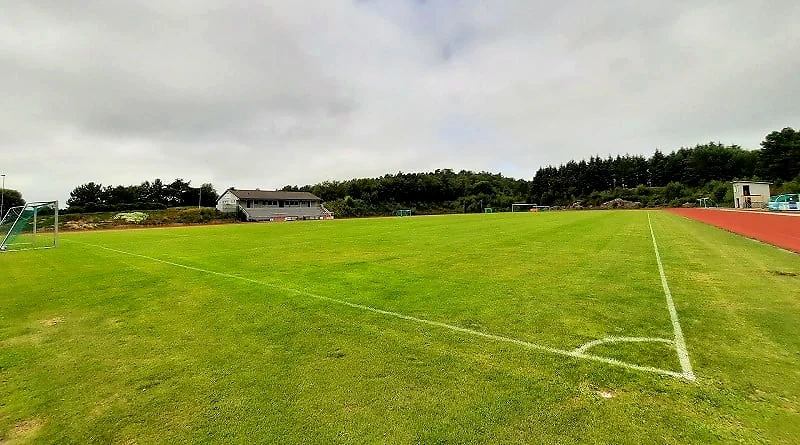 Athletics track with a running track and grass field.