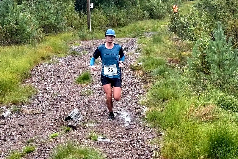 Løper i terrengløp, nummer 28, på sti med gress og stein.