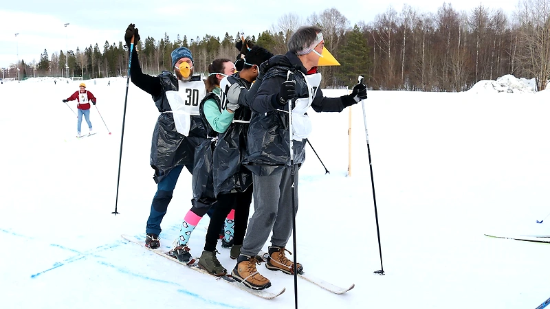 Group on skis with fun costumes, possibly for a relay race.