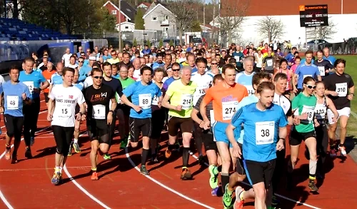 Runners in a race on a track. Many participants with bib numbers.