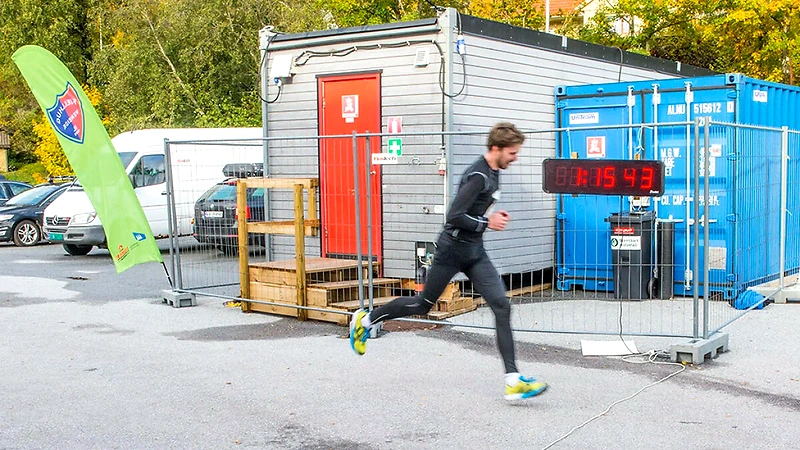 Runner at the finish line with a timer.