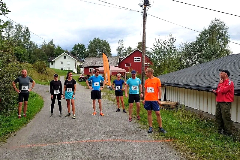 Runners at the starting line for a race in a rural setting.