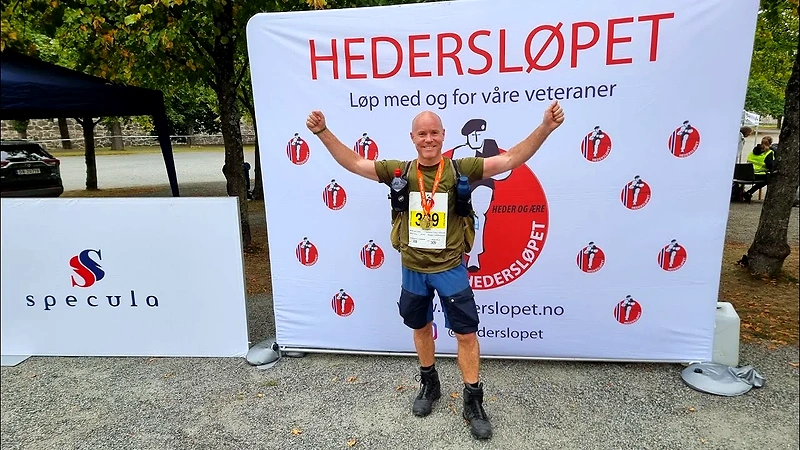 Runner with medal in front of the Honor Race banner.