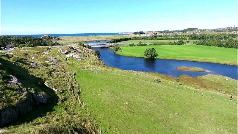Overview image of a beautiful landscape with runners on a path near water.