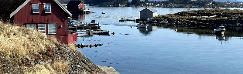 Beautiful coastal landscape with boats and houses, which fits perfectly with the Kyststien Rundt race.