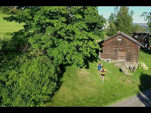 Trail runners in a landscape with wooden houses, possibly during the Leden race.