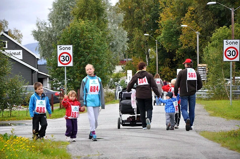 Running event with families, children, and adults with race numbers.