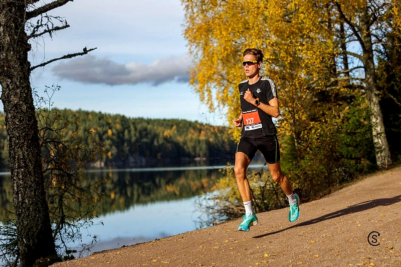Runner on the trail by the water in Nøklevann Rundt.