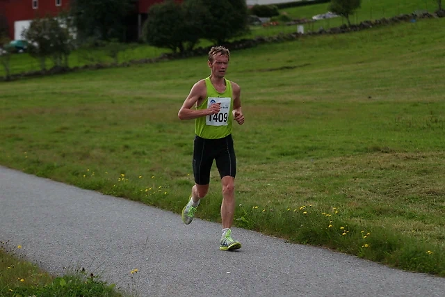 Runner in the Northwest Marathon with bib number 1409 on a country road.