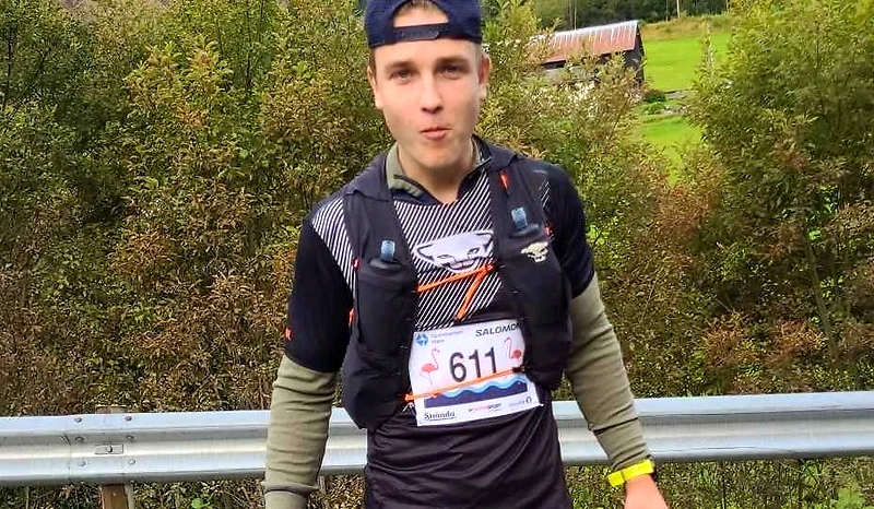 Runner with bib number 611 during a race, wearing a running vest and cap.