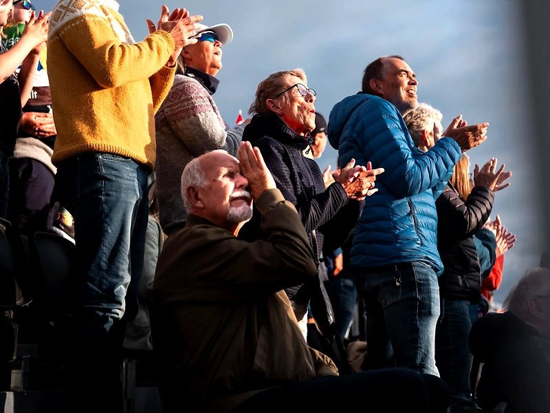 Spectators are applauding at a racing event, creating a great atmosphere and support.