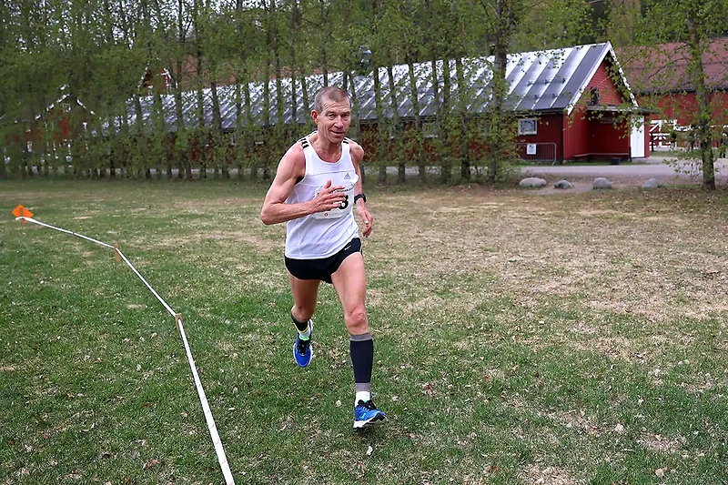 Runner in the race carousel, Sagtomta. Man runs across the grass.
