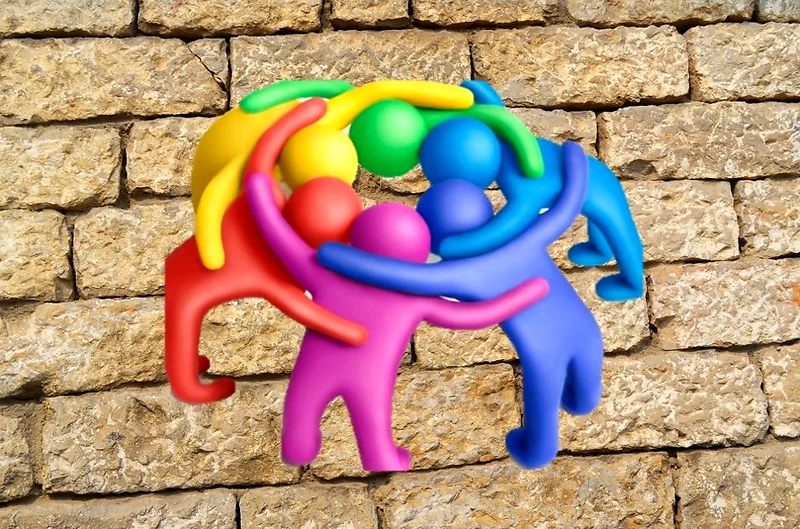 Illustration of colorful figures embracing each other, representing community.