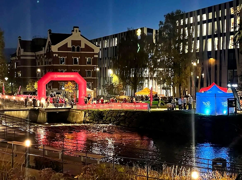 Pink Ribbon Run Oslo. Nighttime image of the event with pink decorations and people.