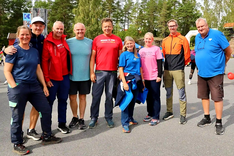 Participants in the Røykenmila race, some in running clothes and race logos.
