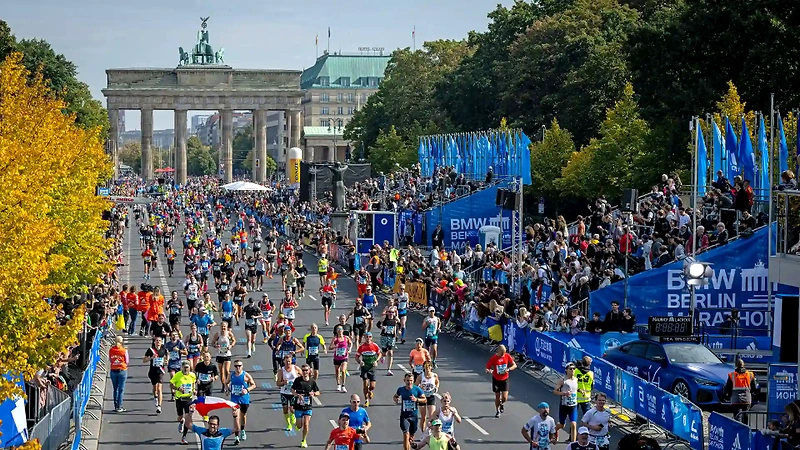 Runners in the BMW Berlin Marathon, with the Brandenburg Gate in the background.