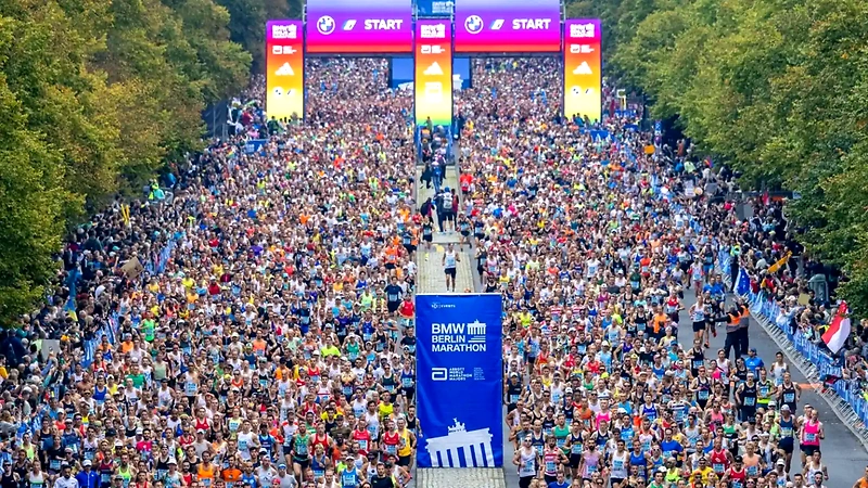 BMW Berlin Marathon, a large race with many runners at the starting area, with the race logo in the foreground.