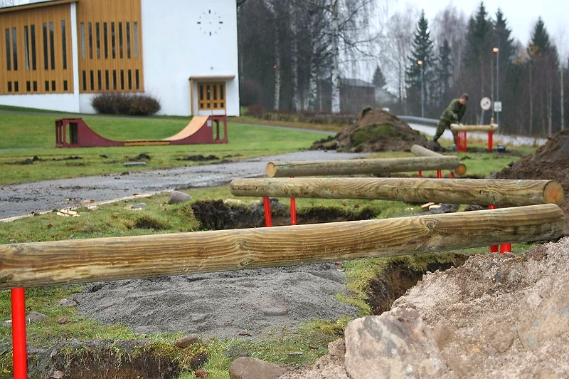 Trail course with obstacles. Man builds an obstacle.