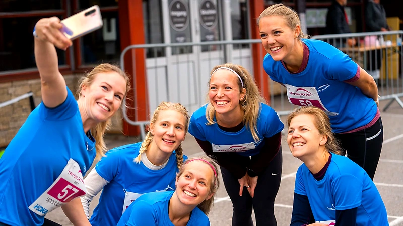 Women are taking selfies at Trysilrypa. They are wearing running clothes and smiling.