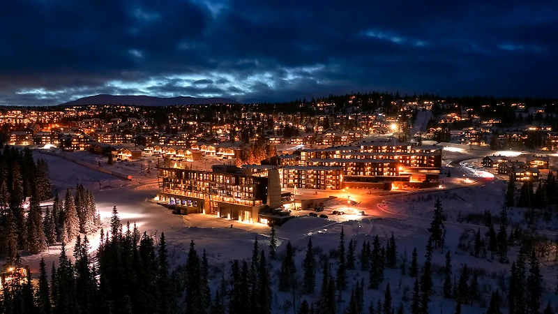 Winter landscape with lights in buildings, possibly SkiStar Lodge at Trysilfjellet.