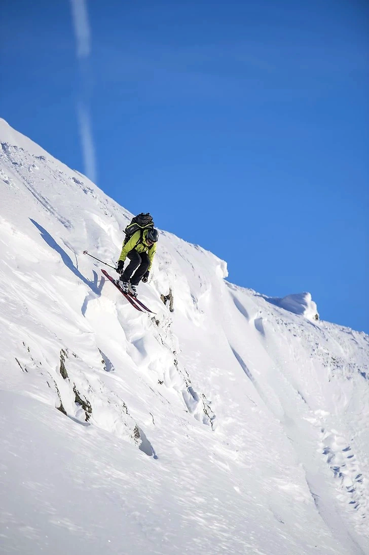 Skier heading down a snow-covered mountain.
