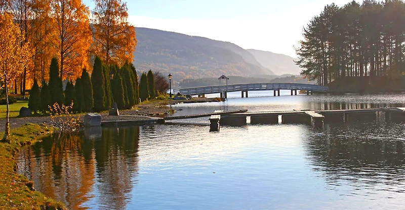 Scenic landscape with water, trees, and a bridge. Potentially related to the Valdresløpet.