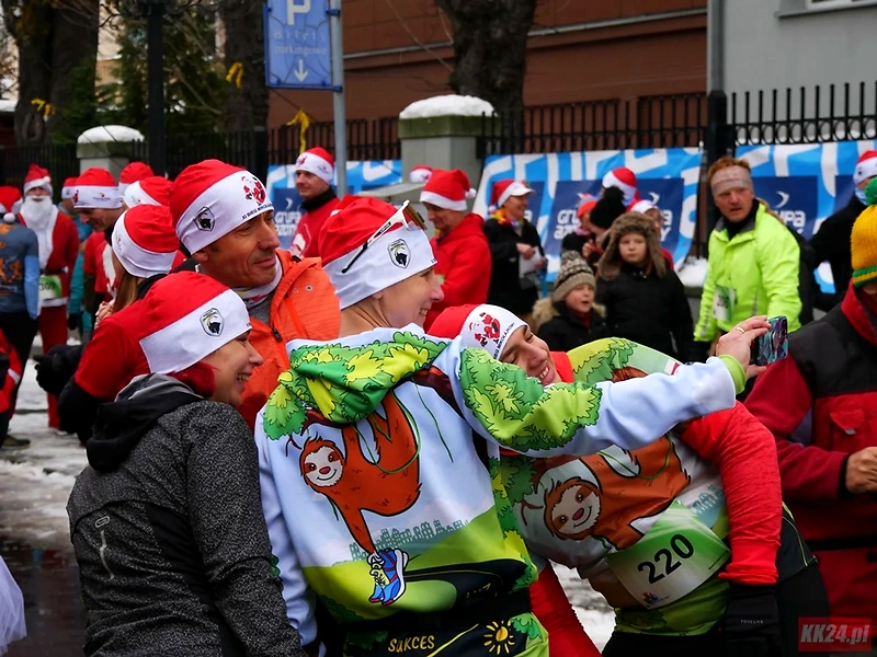 Biegacze w czapkach Mikołaja robią selfie na 13 Bieg Mikołajkowy.