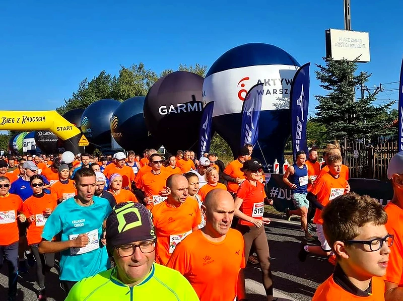 Bieg z Radością - początek biegu, tłum biegaczy, balony reklamowe.