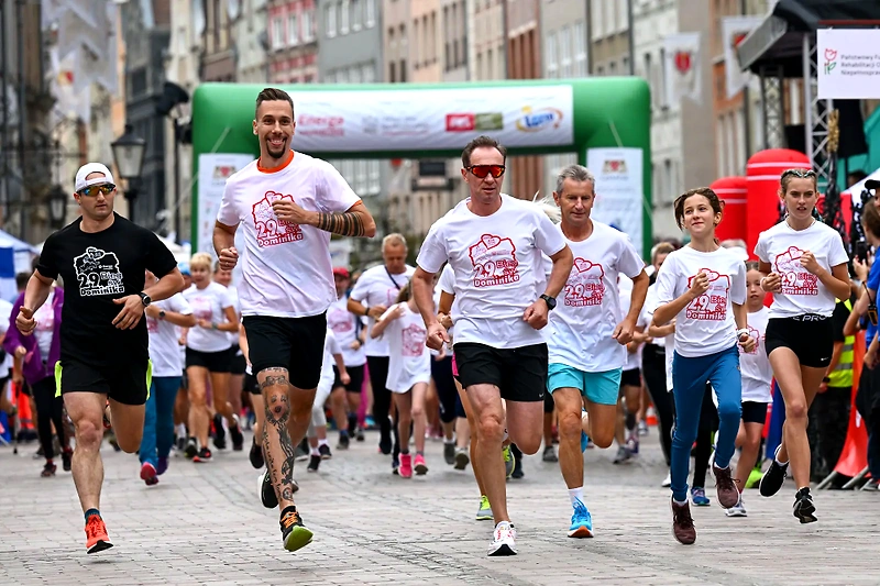 Uczestnicy biegu w koszulkach z logo 